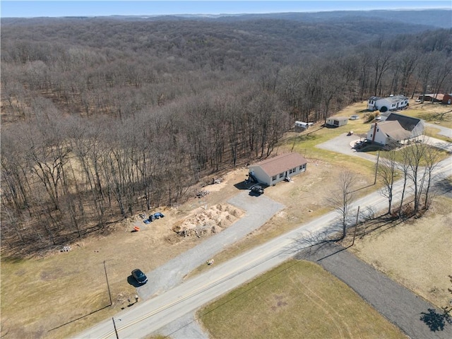 drone / aerial view featuring a view of trees and a rural view