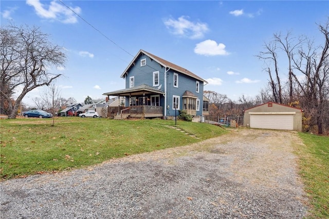 view of front of property featuring a garage, an outbuilding, and a front lawn