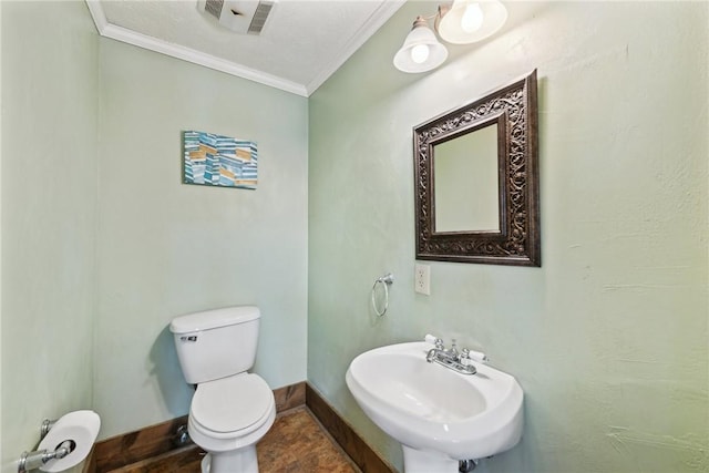 bathroom featuring visible vents, crown molding, baseboards, toilet, and a sink