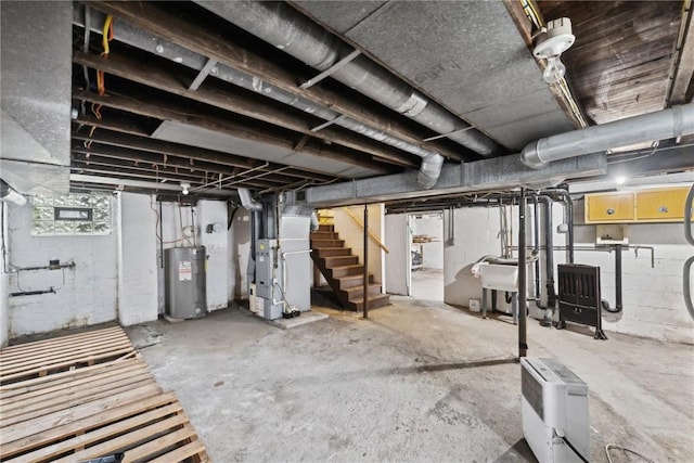 basement featuring water heater, heating unit, and stairs