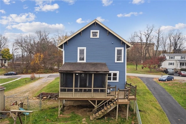 back of property with a sunroom, fence, stairway, a yard, and a shingled roof