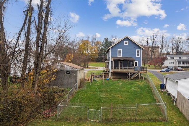 rear view of house with a gate, a lawn, a sunroom, and fence private yard