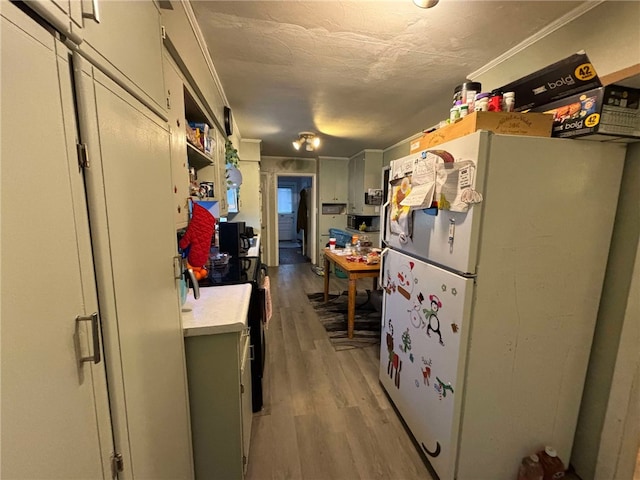 319 Cedar Ave, Sharon, PA 16146 - kitchen with light countertops, light wood-style floors, freestanding refrigerator, and ornamental molding
