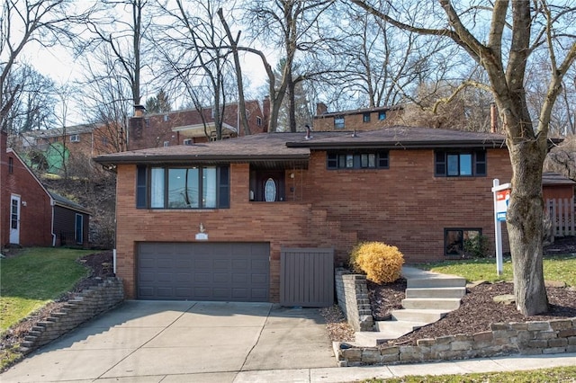 tri-level home with brick siding, an attached garage, driveway, and a front lawn