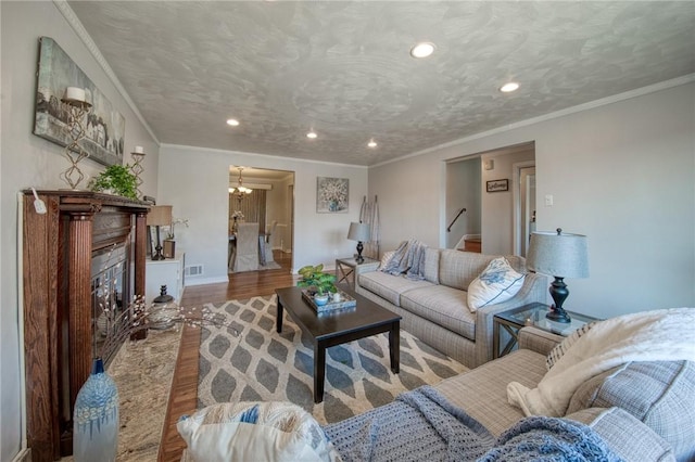 living area with visible vents, a textured ceiling, wood finished floors, and a fireplace