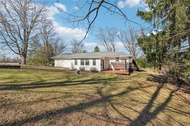 rear view of property featuring a lawn and a wooden deck