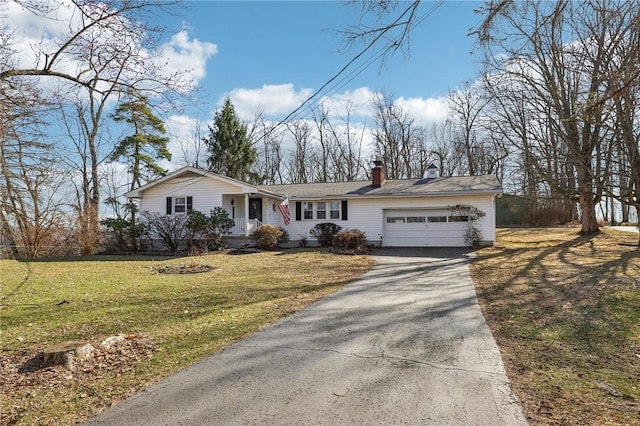 ranch-style home with driveway, a chimney, a garage, and a front yard