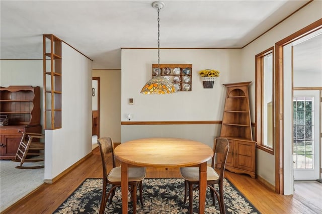 dining space with light wood-type flooring and baseboards