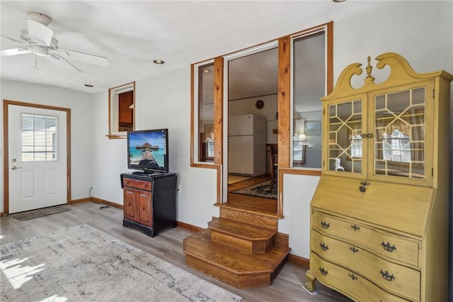 interior space featuring stairway, wood finished floors, baseboards, and ceiling fan