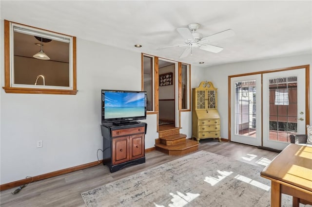 unfurnished living room featuring baseboards, light wood-style flooring, and a ceiling fan