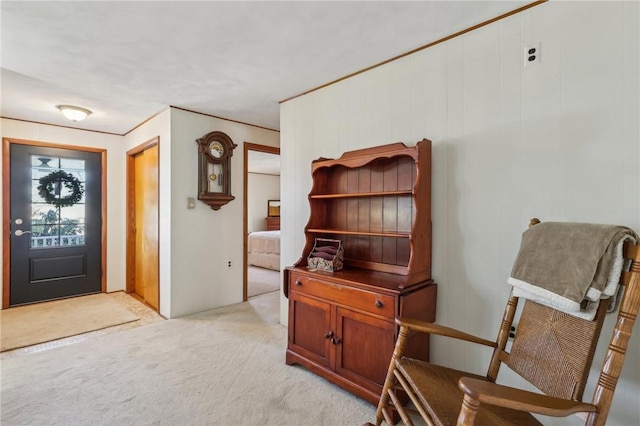 entrance foyer with light carpet and ornamental molding