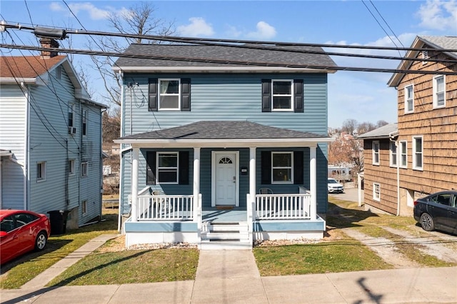 view of front facade featuring covered porch and a shingled roof