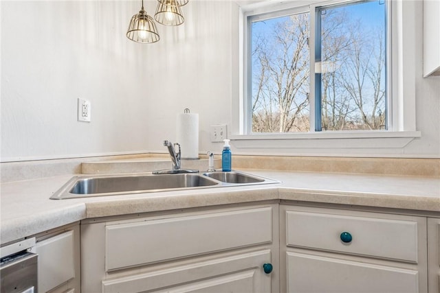 kitchen featuring a sink, white cabinets, and light countertops