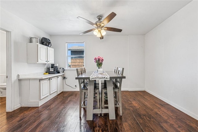 dining area with dark wood finished floors, baseboards, and ceiling fan