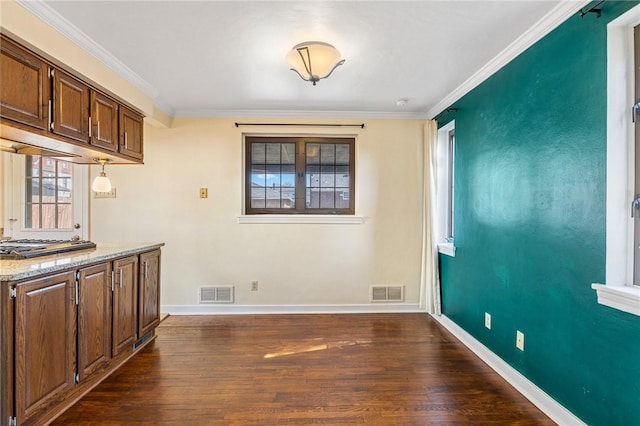 kitchen with dark wood-style floors, visible vents, crown molding, and baseboards