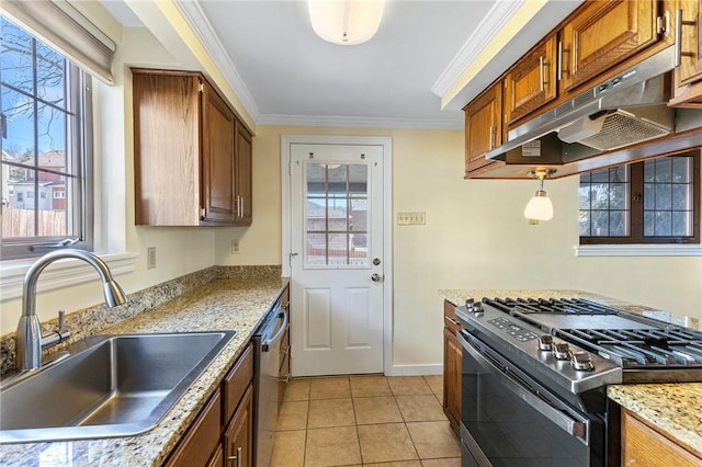 kitchen with under cabinet range hood, ornamental molding, light tile patterned floors, appliances with stainless steel finishes, and a sink