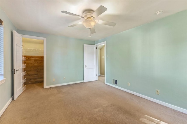 unfurnished bedroom with carpet flooring, baseboards, visible vents, and a spacious closet