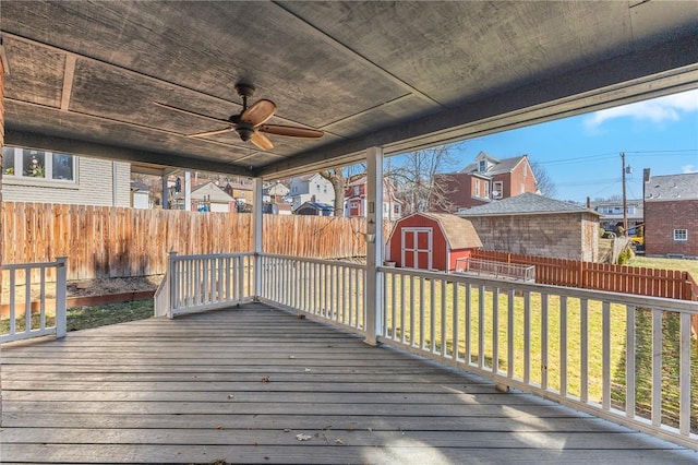 deck with a yard, an outbuilding, a fenced backyard, and a shed