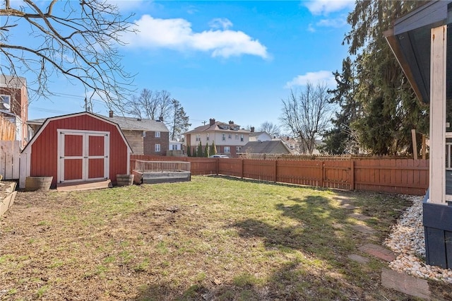 view of yard with an outbuilding, a fenced backyard, and a shed