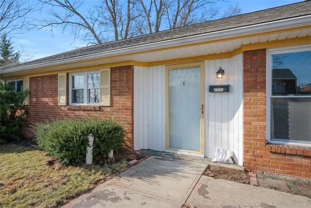 doorway to property featuring brick siding