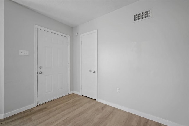 interior space with wood finished floors, visible vents, and baseboards