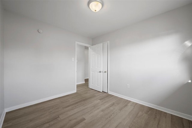 unfurnished room with baseboards and wood finished floors