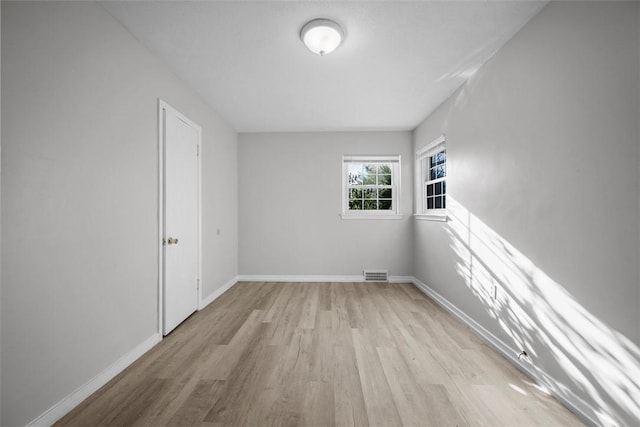 spare room with visible vents, baseboards, and light wood-style floors