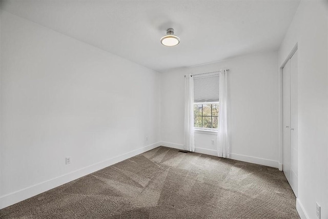 unfurnished room featuring baseboards and carpet