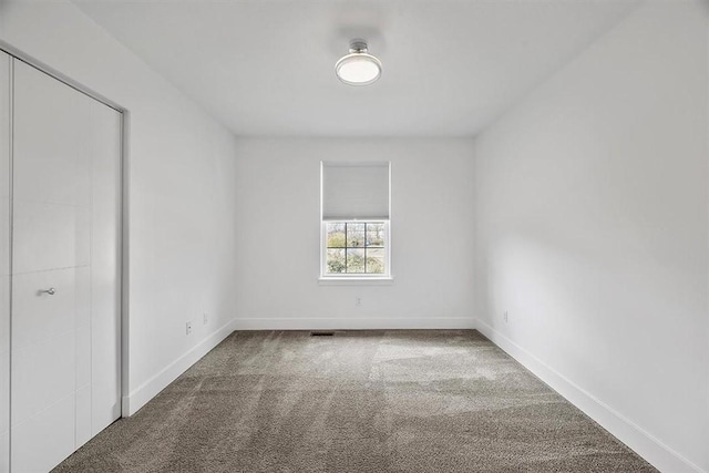 carpeted spare room with baseboards