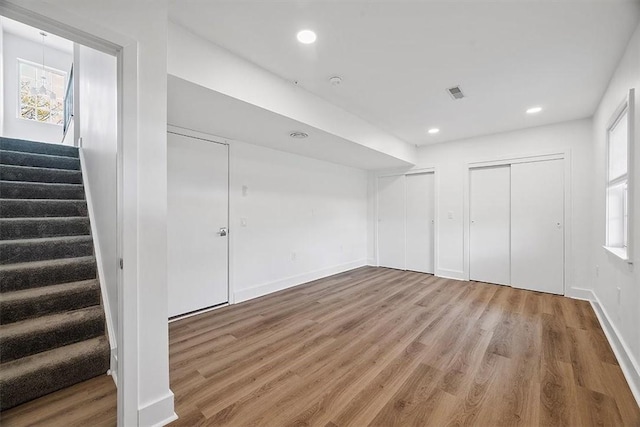 interior space with visible vents, baseboards, multiple closets, recessed lighting, and wood finished floors