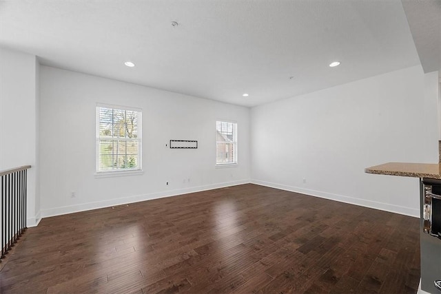 unfurnished room with recessed lighting, dark wood-style floors, and baseboards