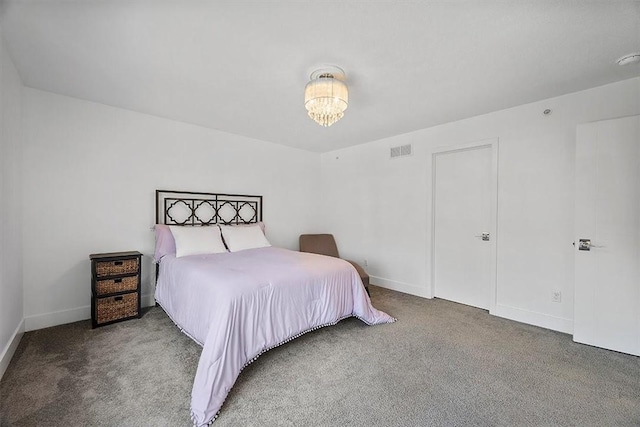 carpeted bedroom featuring visible vents, baseboards, and a chandelier