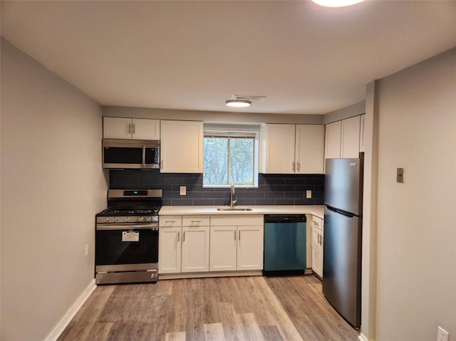 60 Broadhead Ave, Crafton, PA 15205 - kitchen featuring light wood-style flooring, a sink, stainless steel appliances, light countertops, and decorative backsplash