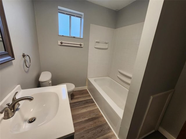 full bath with toilet, vanity, baseboards, and wood finished floors