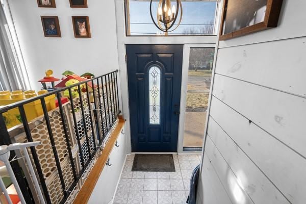 entryway featuring light tile patterned floors and a notable chandelier