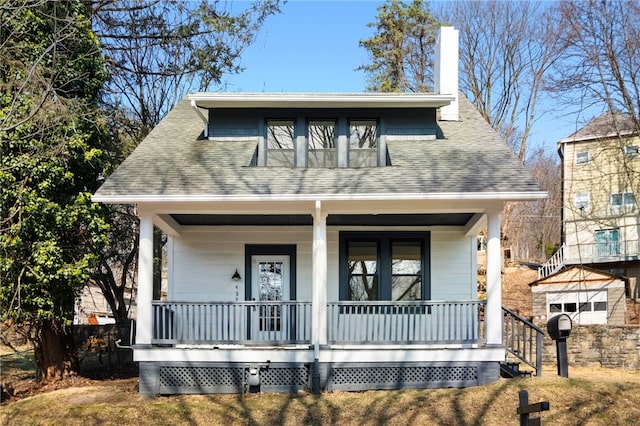 bungalow with a chimney, a porch, and a shingled roof