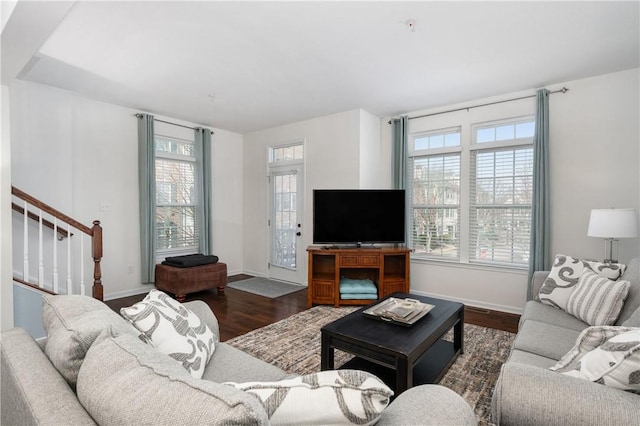 living room featuring dark wood finished floors, stairs, and baseboards