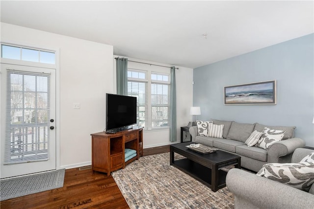 living area featuring baseboards and dark wood-style flooring