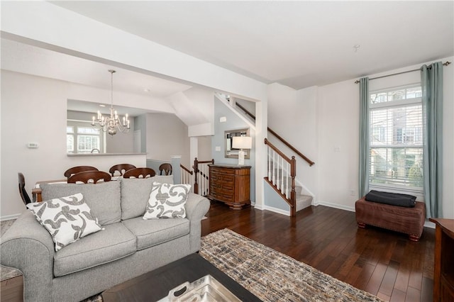 living area with an inviting chandelier, hardwood / wood-style floors, stairs, and a healthy amount of sunlight