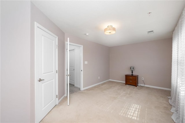 unfurnished bedroom with light carpet, visible vents, and baseboards