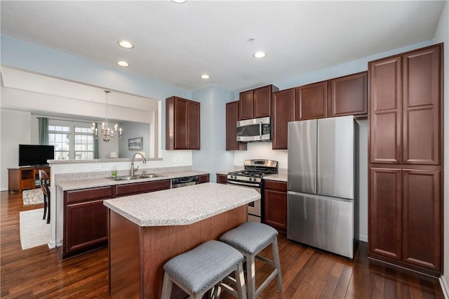 kitchen with light countertops, a peninsula, an inviting chandelier, stainless steel appliances, and a sink