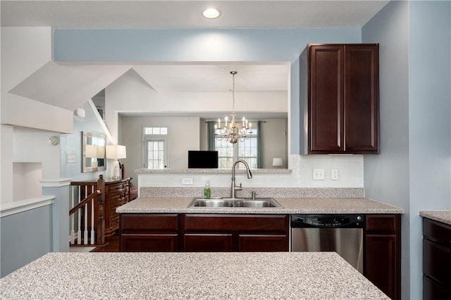 kitchen with a sink, tasteful backsplash, stainless steel dishwasher, an inviting chandelier, and light countertops