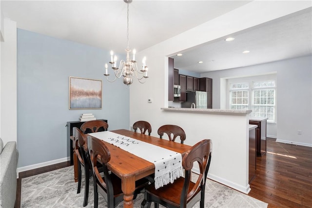 dining space featuring recessed lighting, baseboards, wood-type flooring, and an inviting chandelier