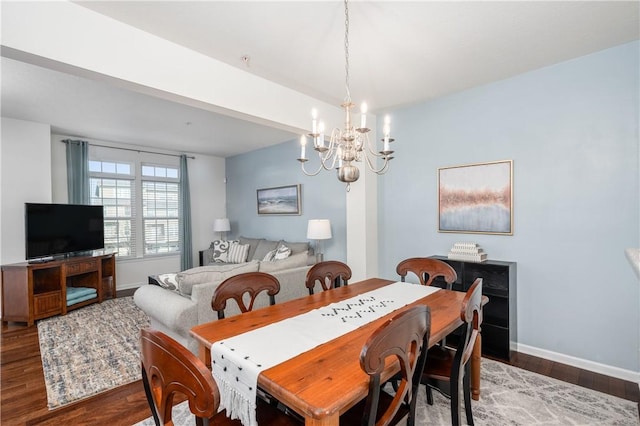 dining area with baseboards, an inviting chandelier, and wood finished floors