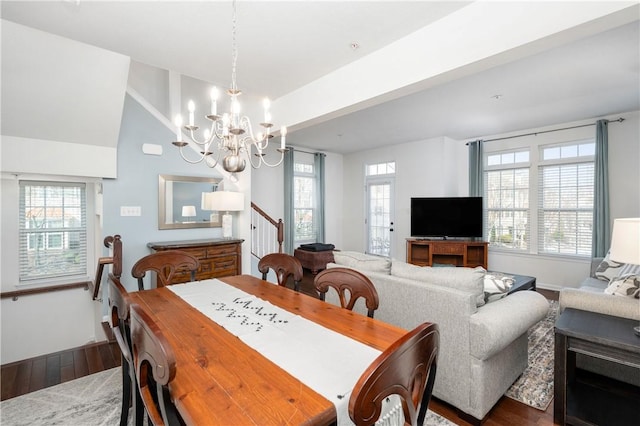 dining area with vaulted ceiling, a notable chandelier, baseboards, and wood finished floors