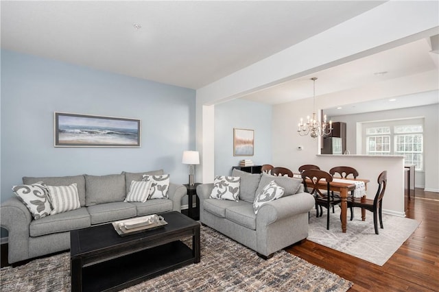 living room featuring a notable chandelier, dark wood-type flooring, and baseboards