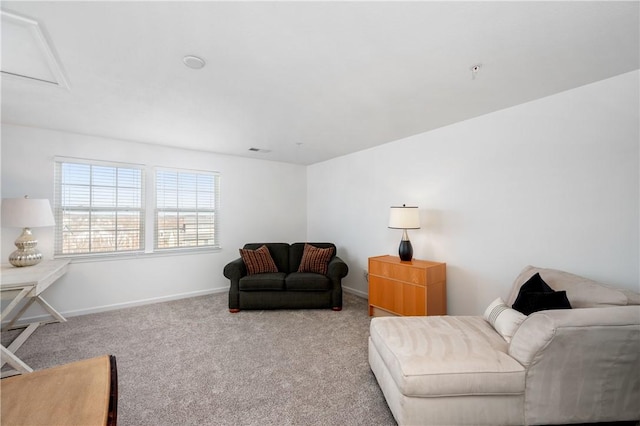 carpeted living room featuring visible vents, attic access, and baseboards