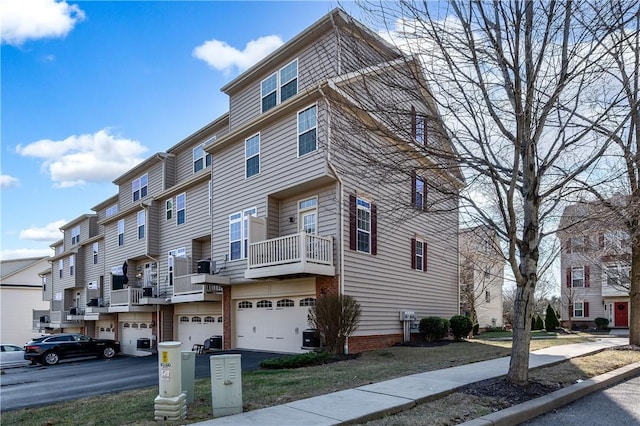 exterior space featuring an attached garage, central AC unit, and a residential view