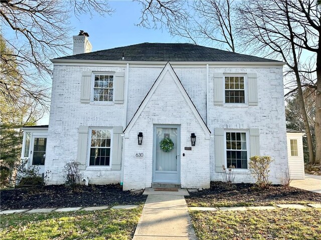 view of front of house featuring brick siding and a chimney