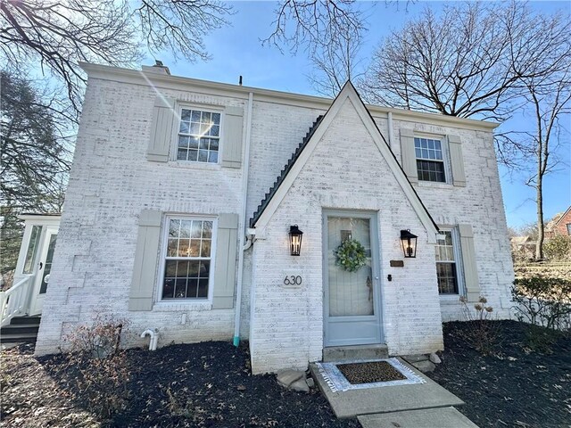 view of front of property with brick siding and a chimney